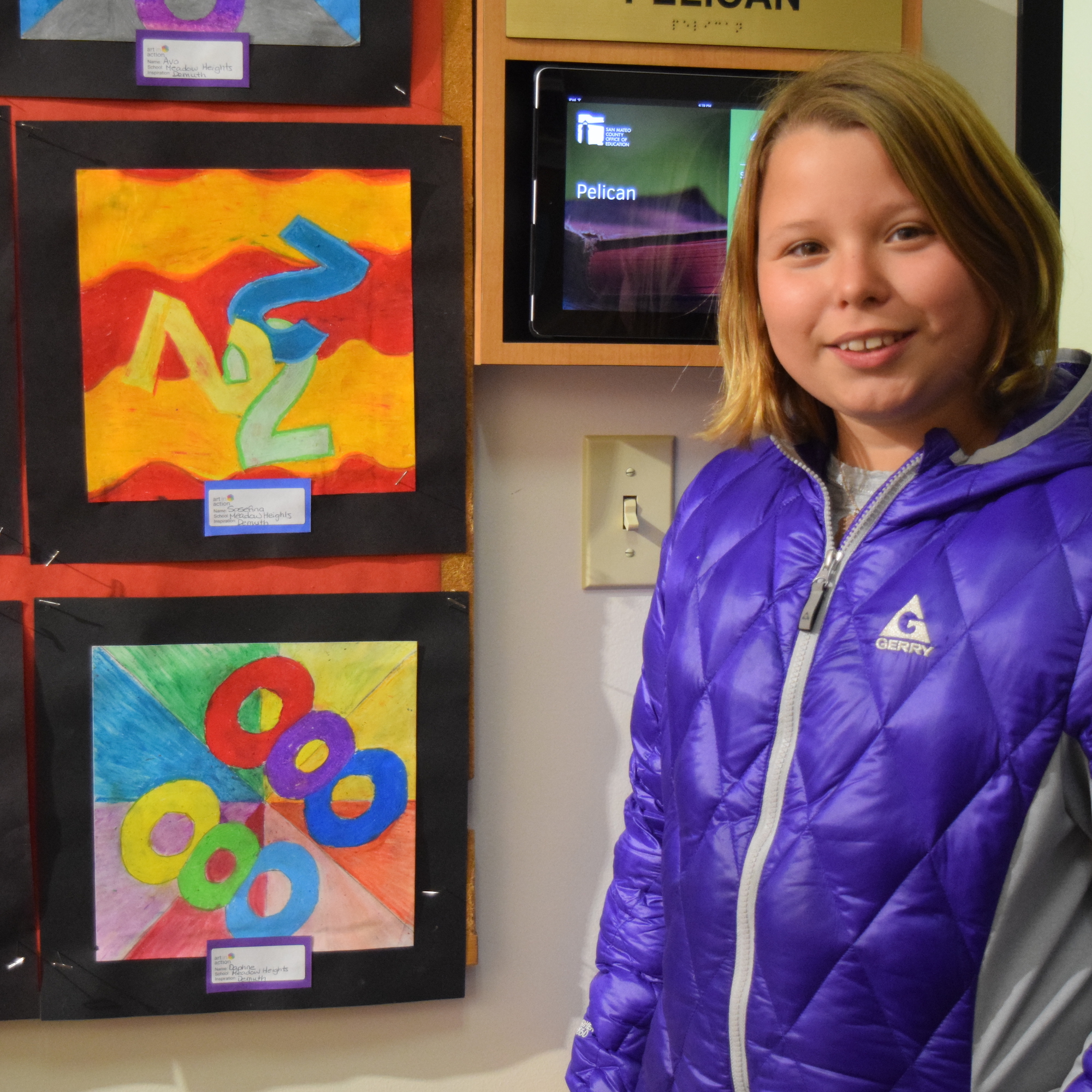 A student stands by her artwork displayed at the 51Թ.